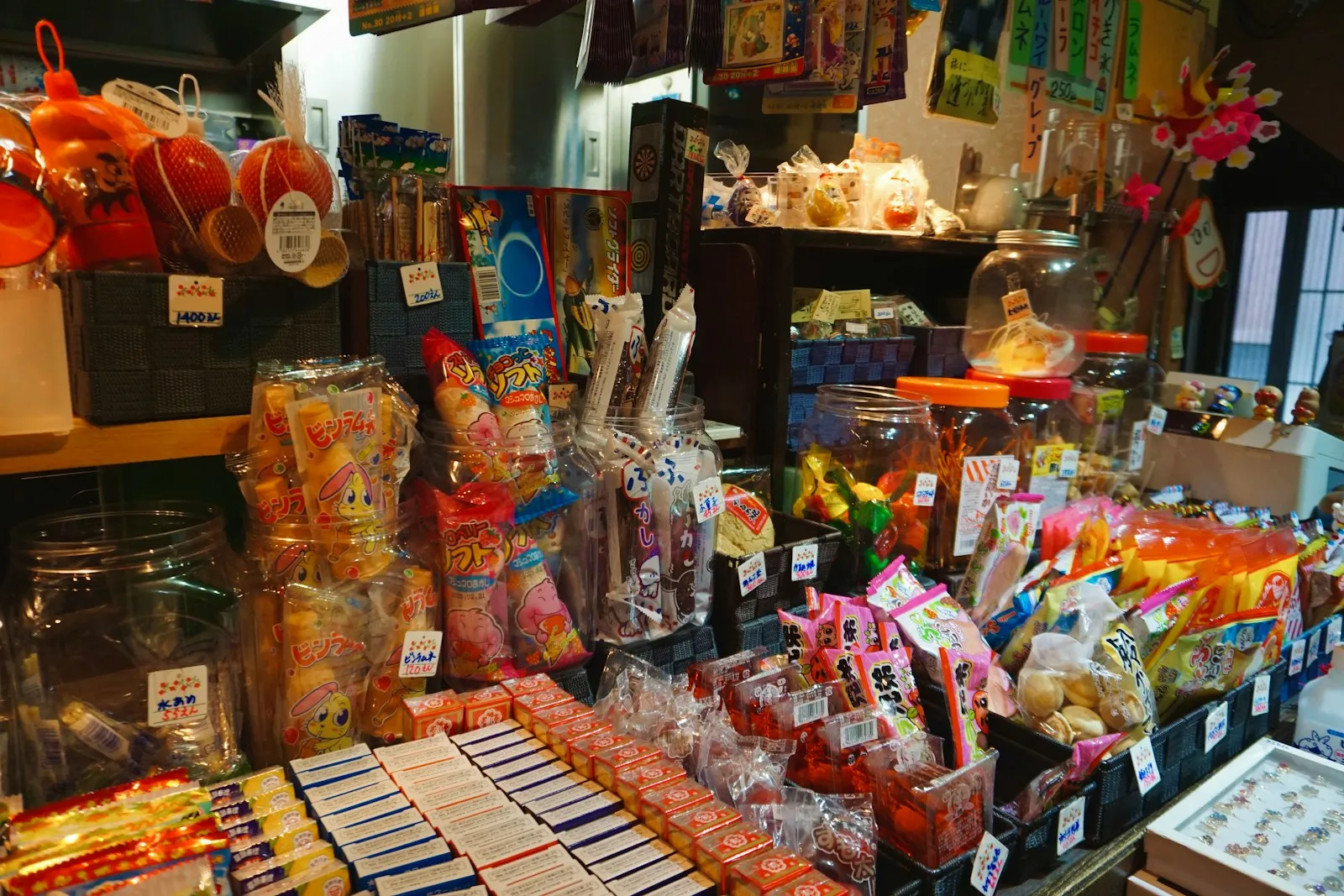 Shelves of brightly packaged Japanese candy filling a small shop.