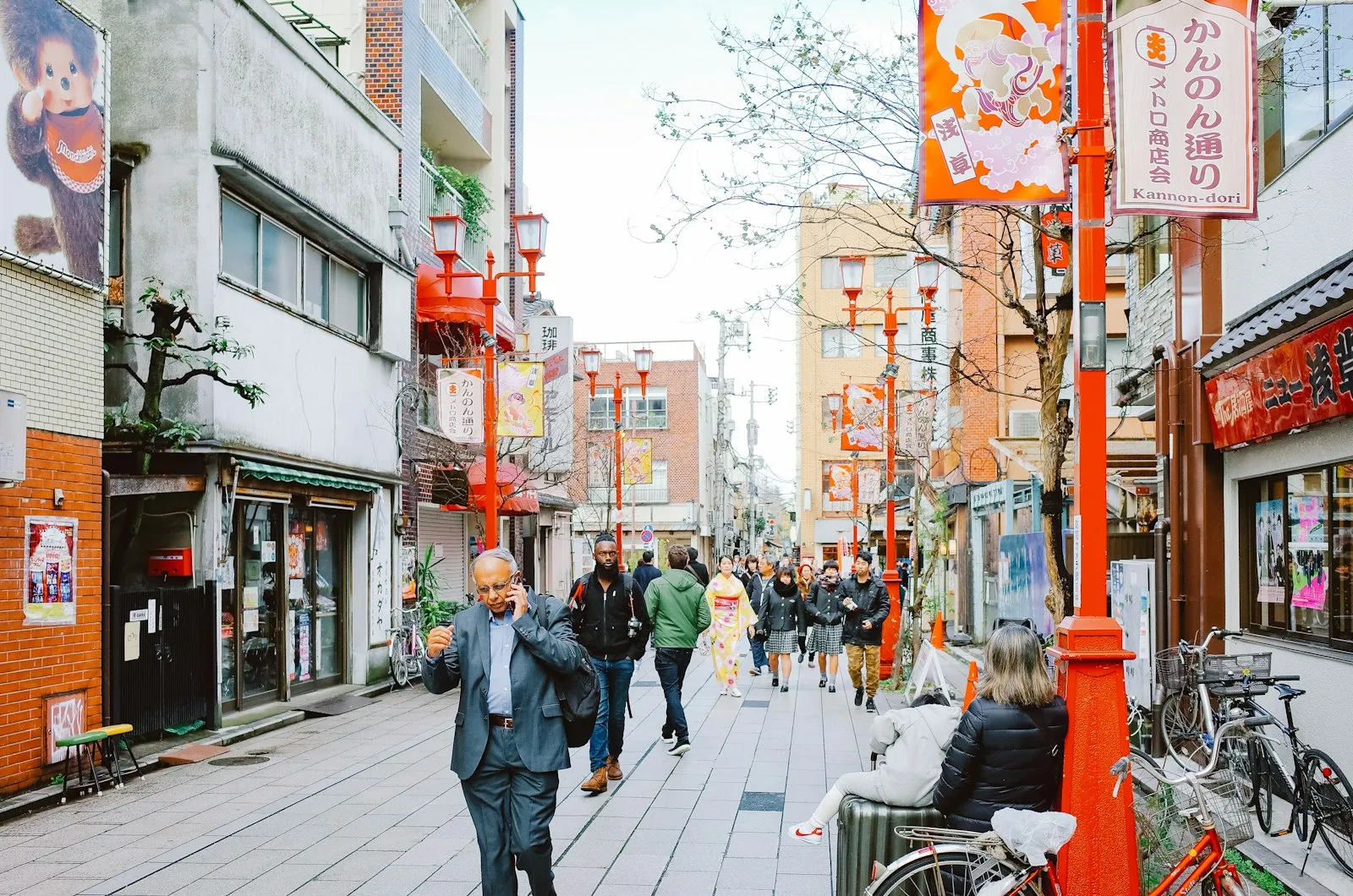 A shopping street in Japan lined with shopfronts, lanterns and signs.