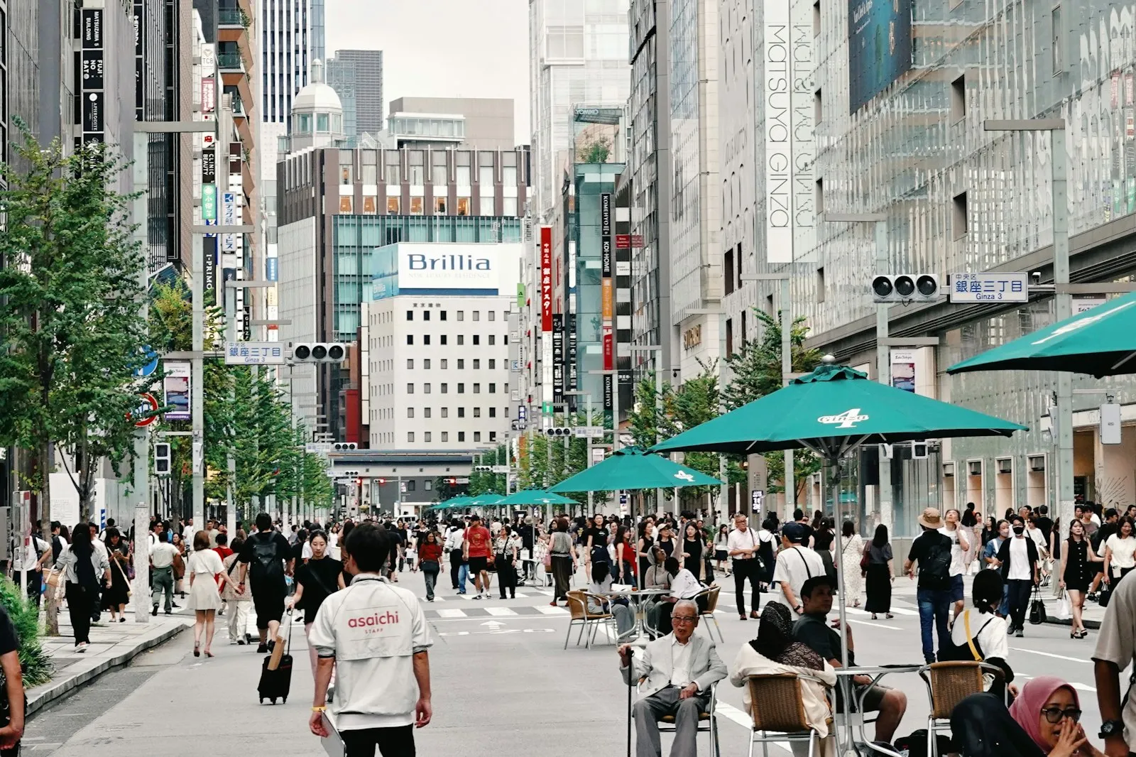 A wide shopping street in Japan crowded with pedestrians.