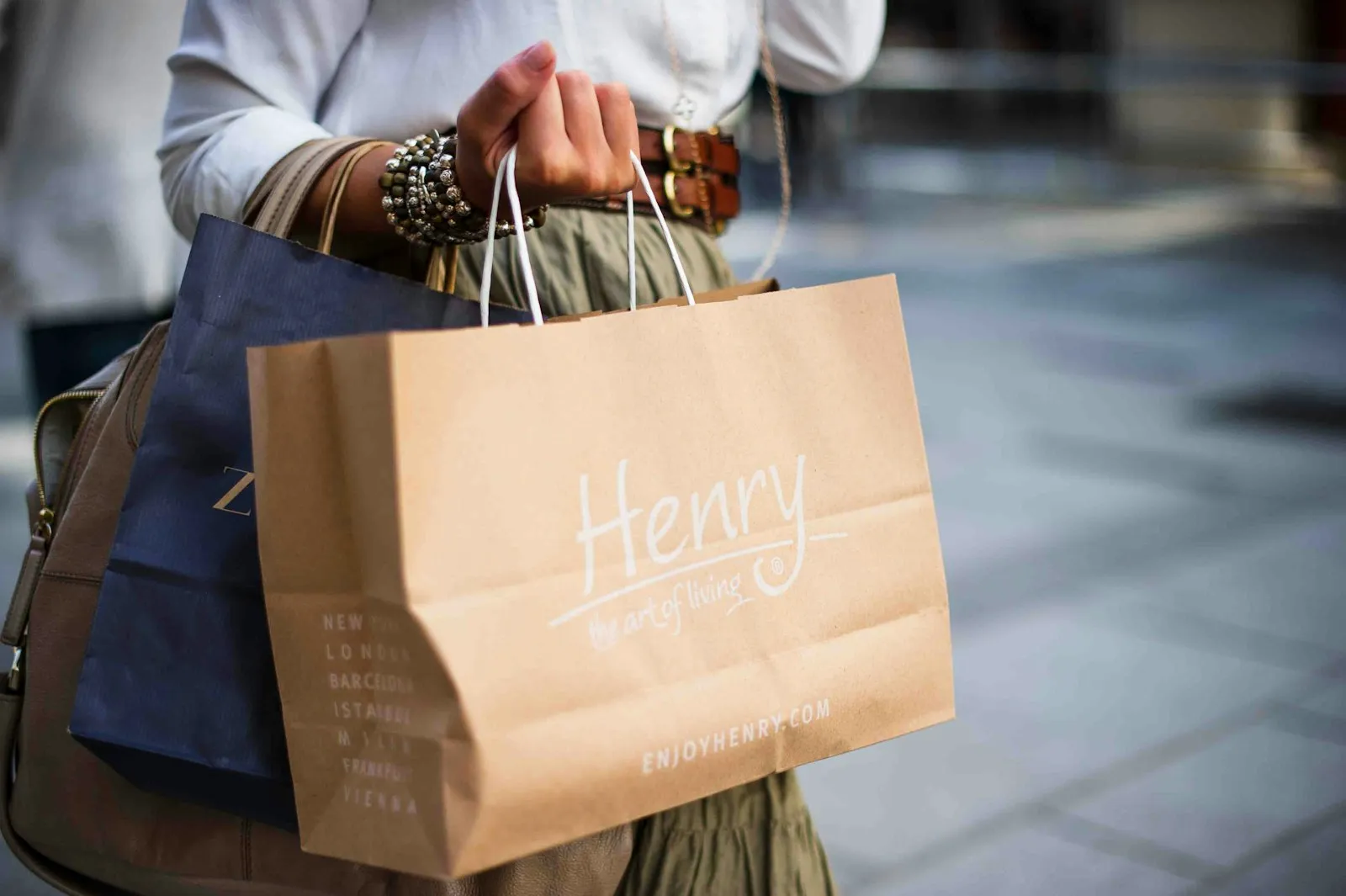 A shopper carrying two paper shopping bags.