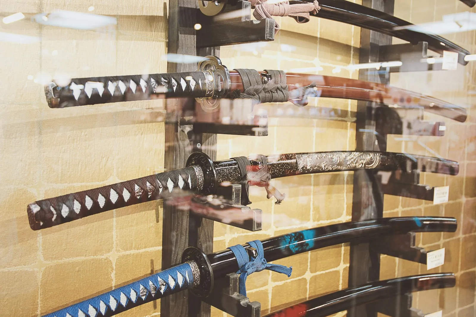 Kitchen knives of several shapes and lengths lined up in a shop display case.